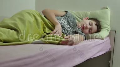 十几岁的男孩睡在床上。 疲惫的、<strong>凌乱</strong>的室内少年睡觉